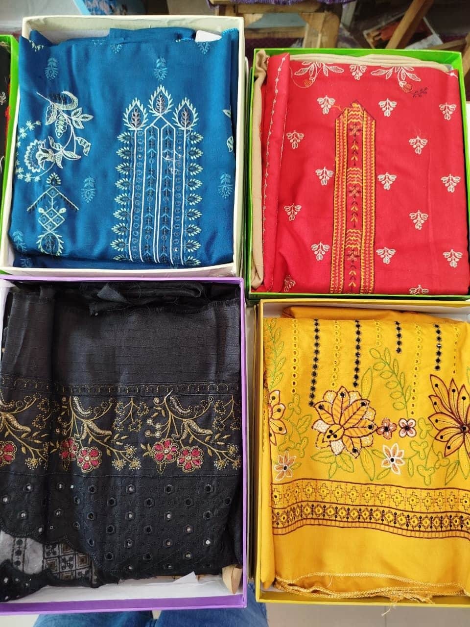 Embroidered festive suits in blue, red, black and yellow boxes at Shahzad Cloth House