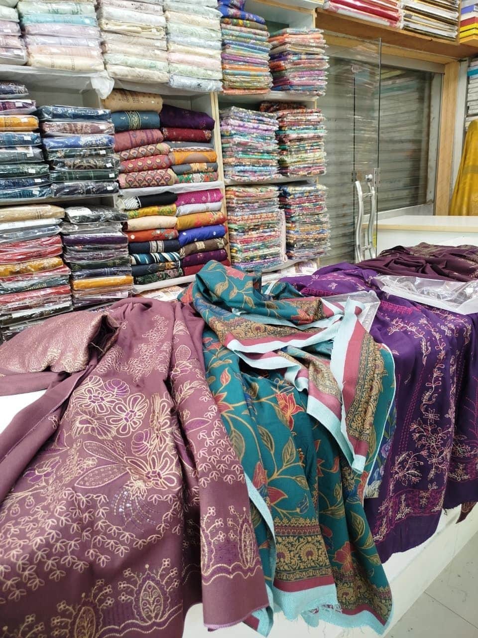 Printed lawn suits spread across the counter at Shahzad Cloth House