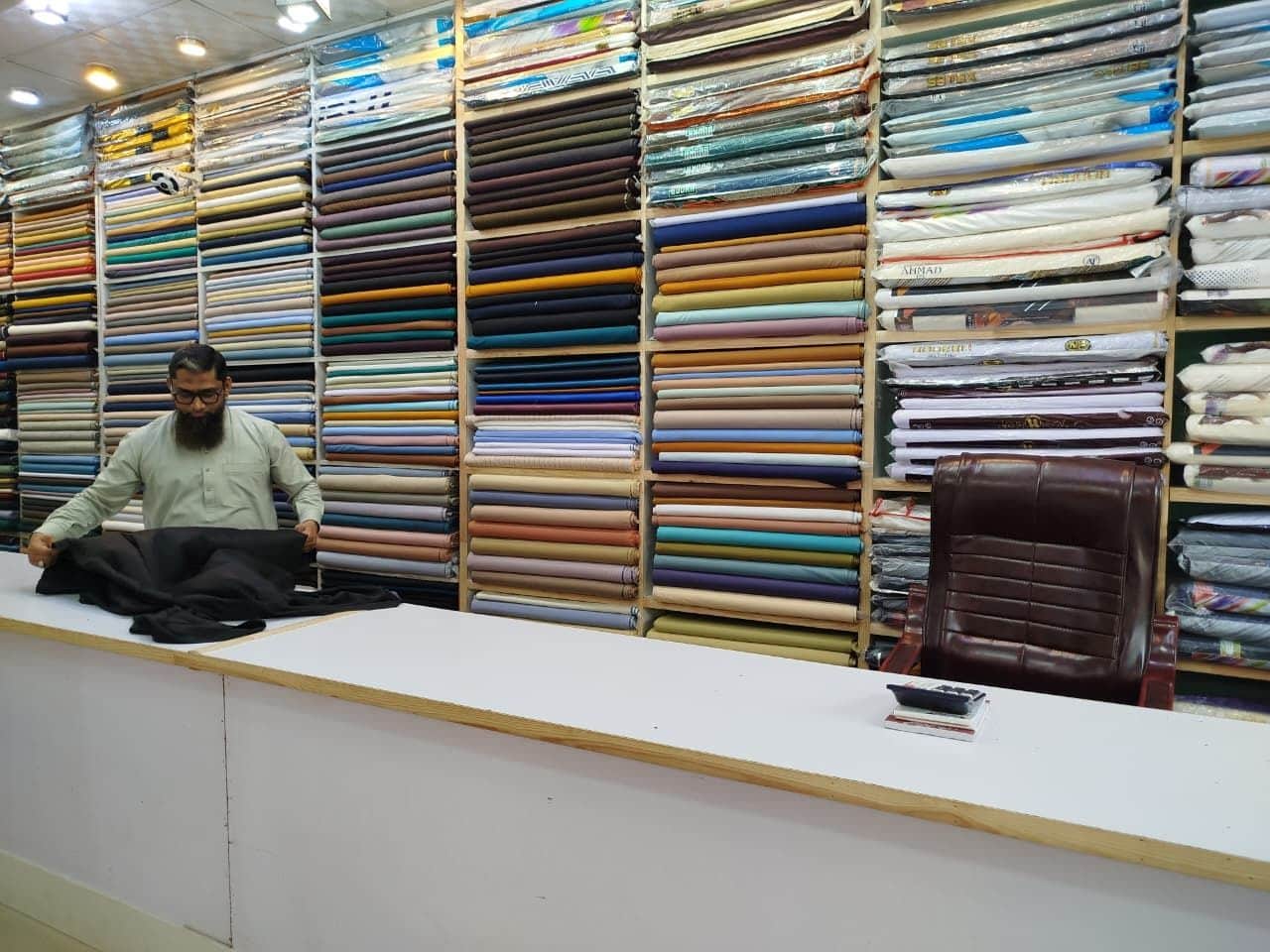 Folding black suiting on the counter at Shahzad Cloth House