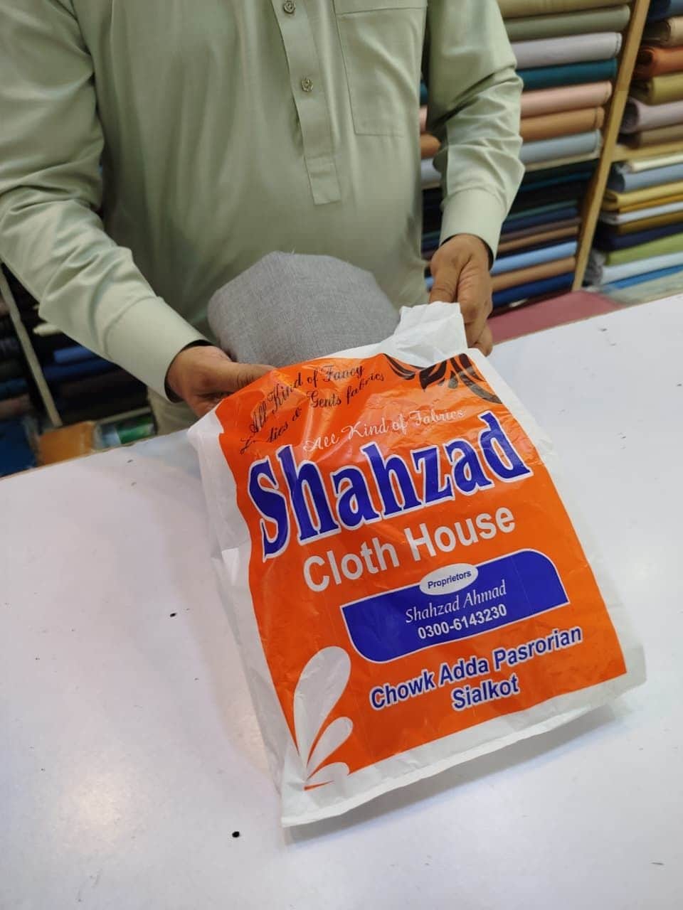 Packing an order in a Shahzad Cloth House bag at the shop counter